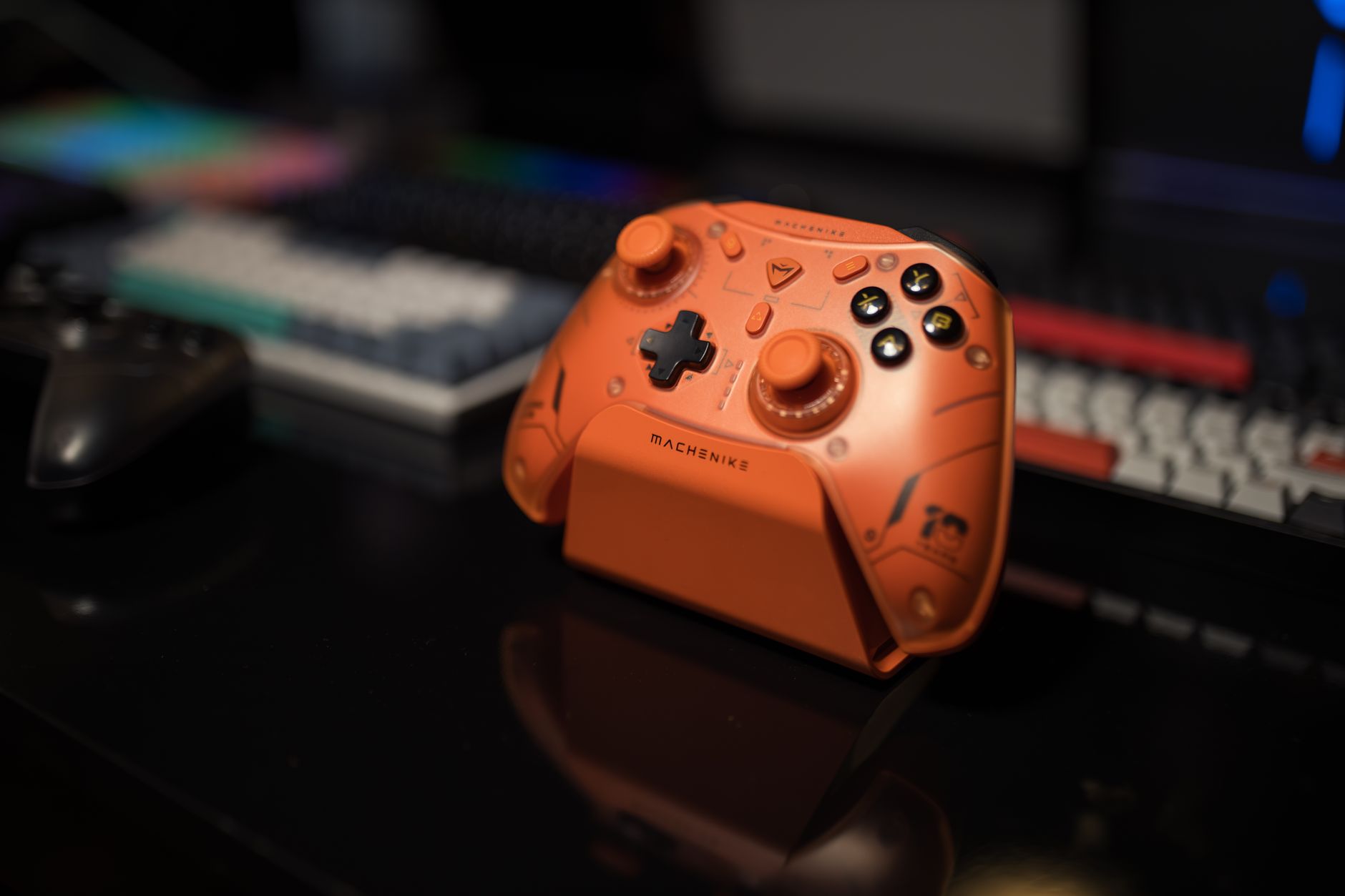 Orange gaming controller on desk with blurred background, ideal for tech enthusiasts.
