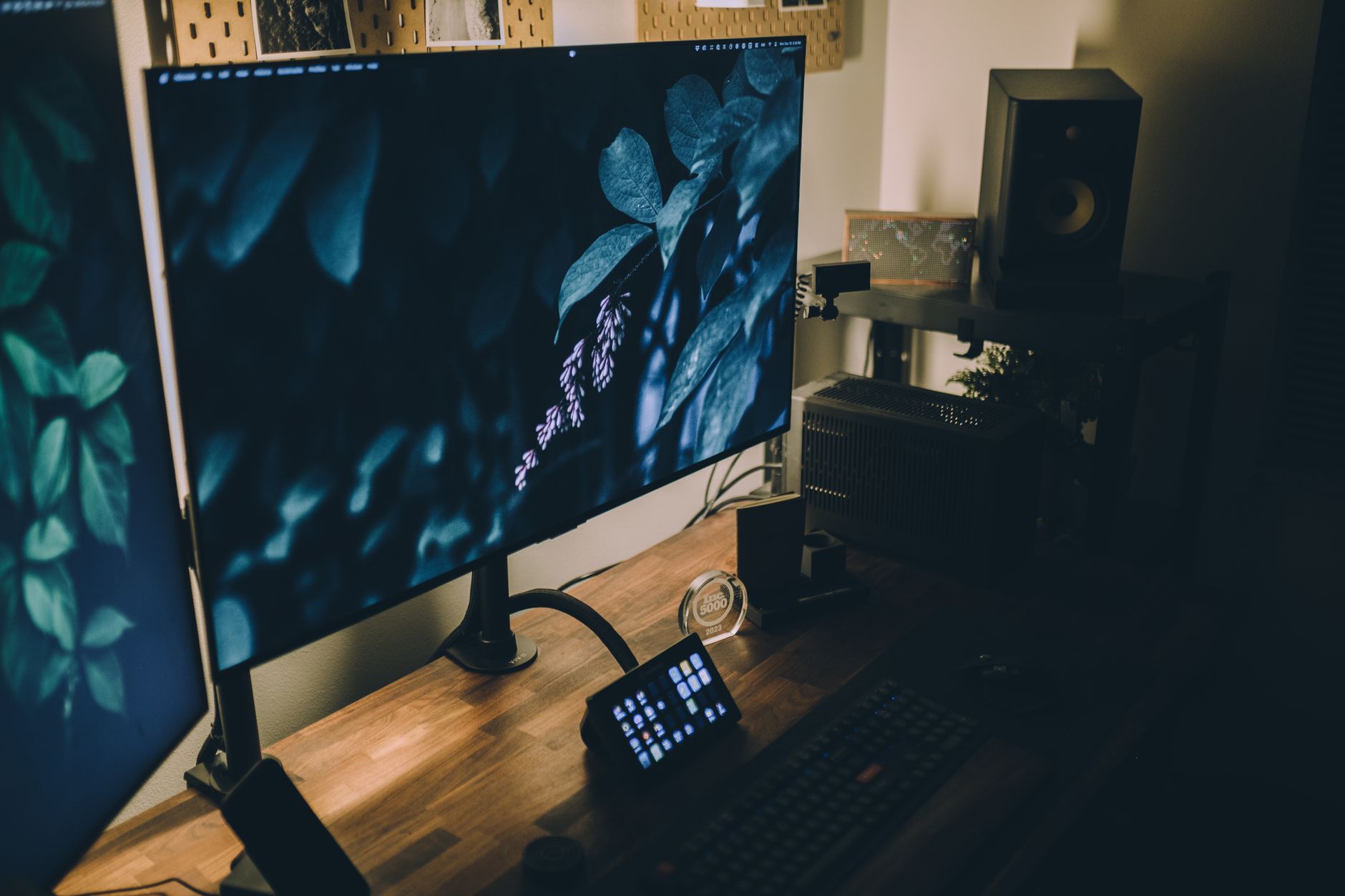 A stylish workspace setup featuring dual monitors, ambient lighting, and a wooden desk.