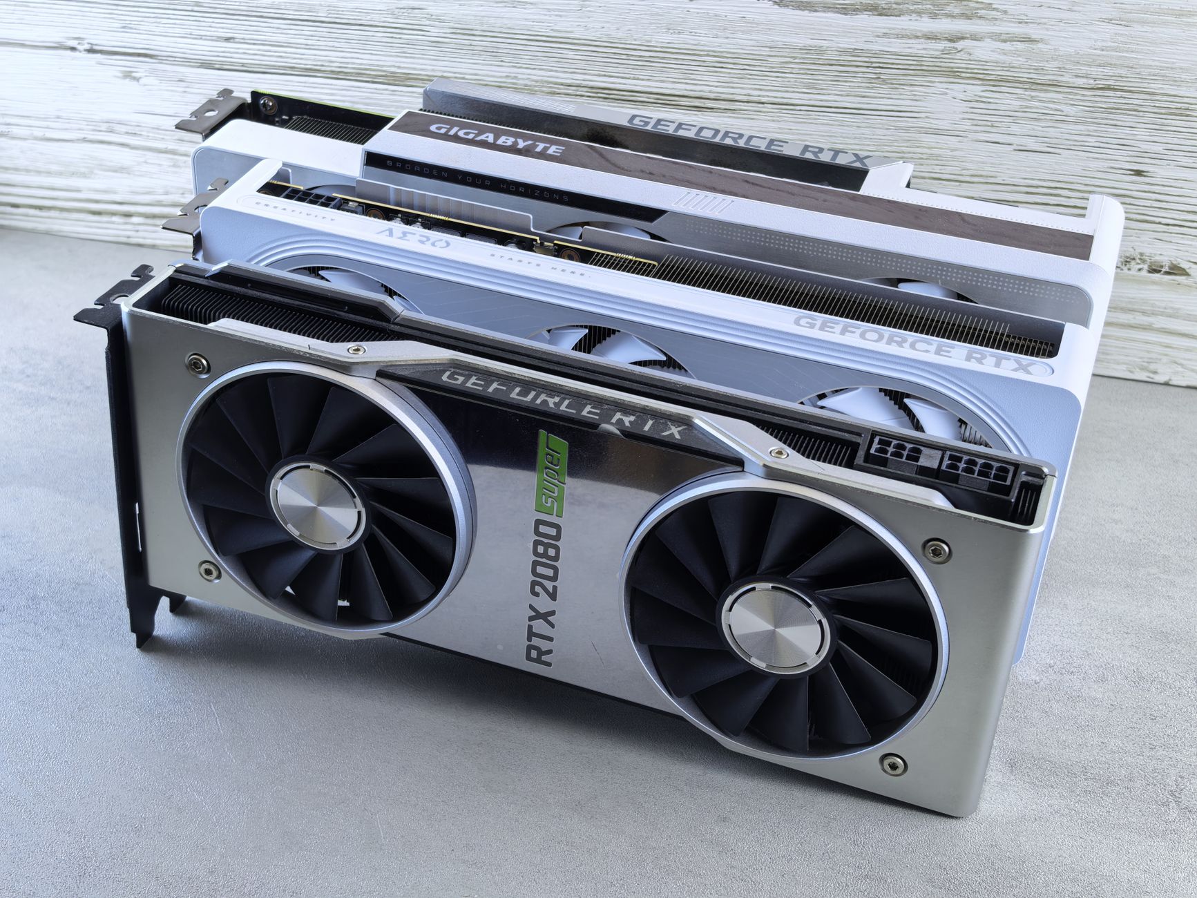 Three NVIDIA GeForce RTX graphics cards stacked on a surface, showcasing their sleek design and branding details.