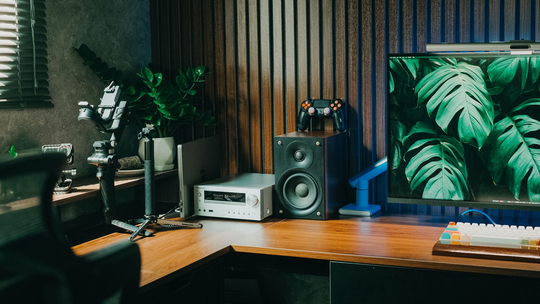 Stylish home office setup with gaming and audio equipment on a wooden desk.
