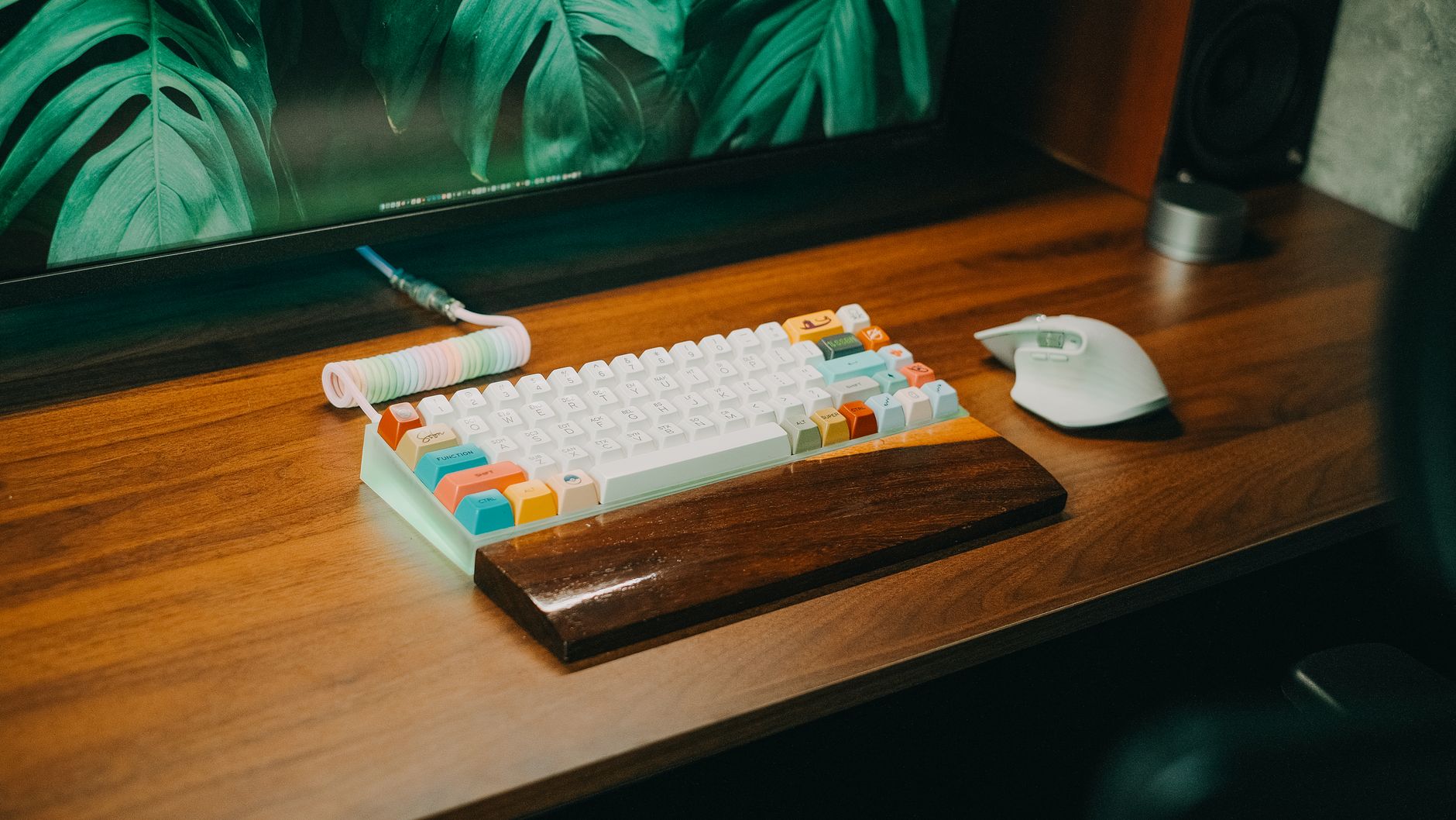 Colorful mechanical keyboard with wrist rest and mouse on sleek wooden desk