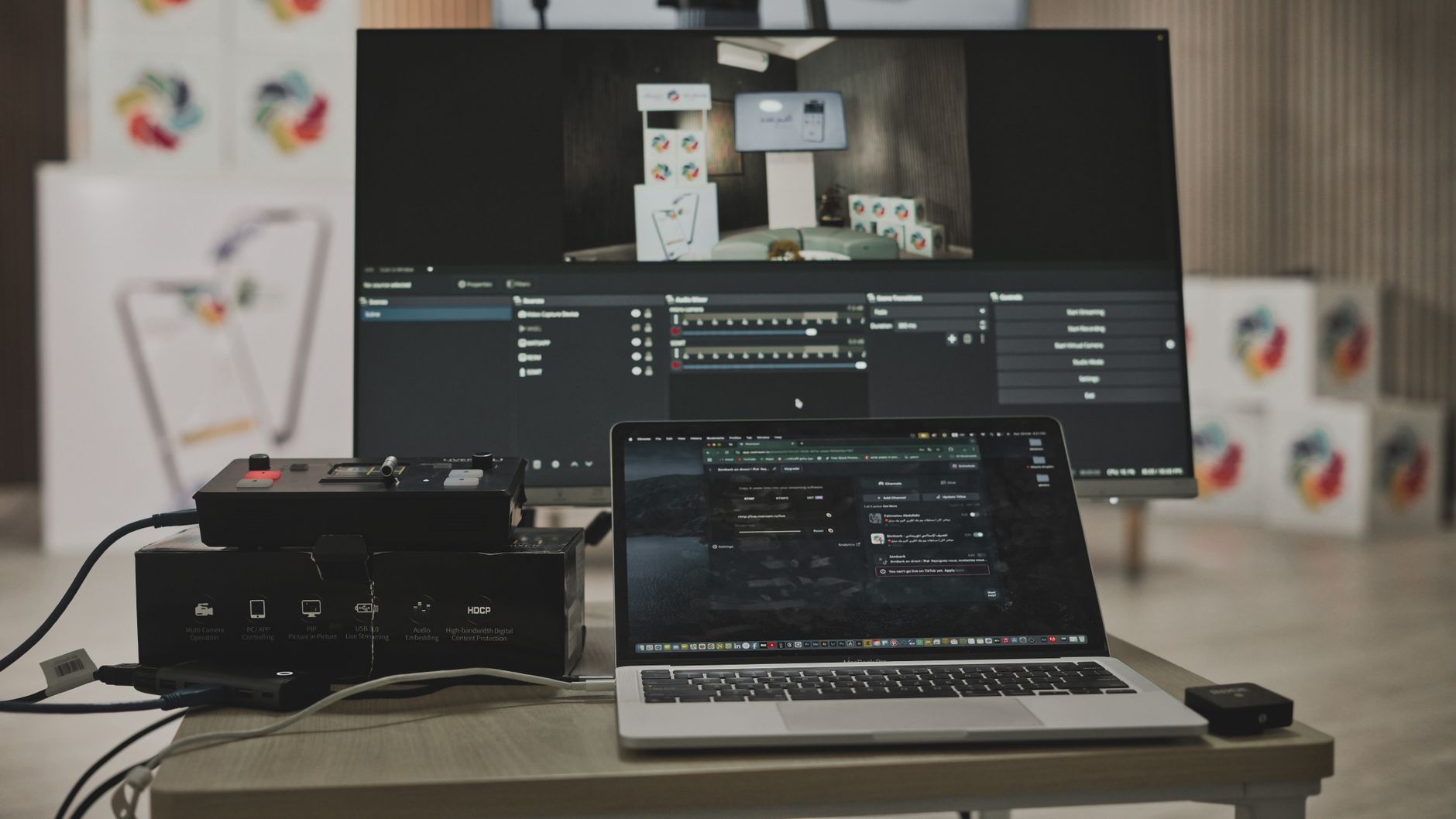 Multimedia setup featuring a laptop and a large monitor in a tech-savvy workspace.
