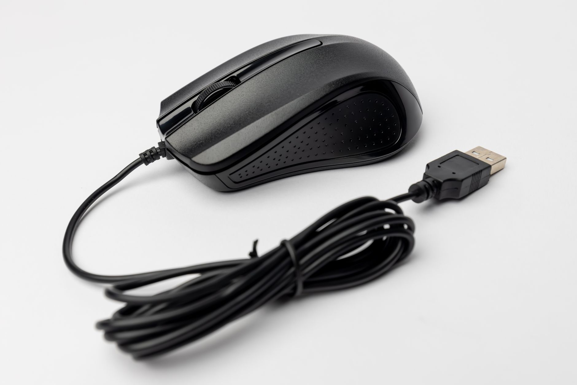 Close-up of a black wired computer mouse on a white background, showcasing its design and connection cable.