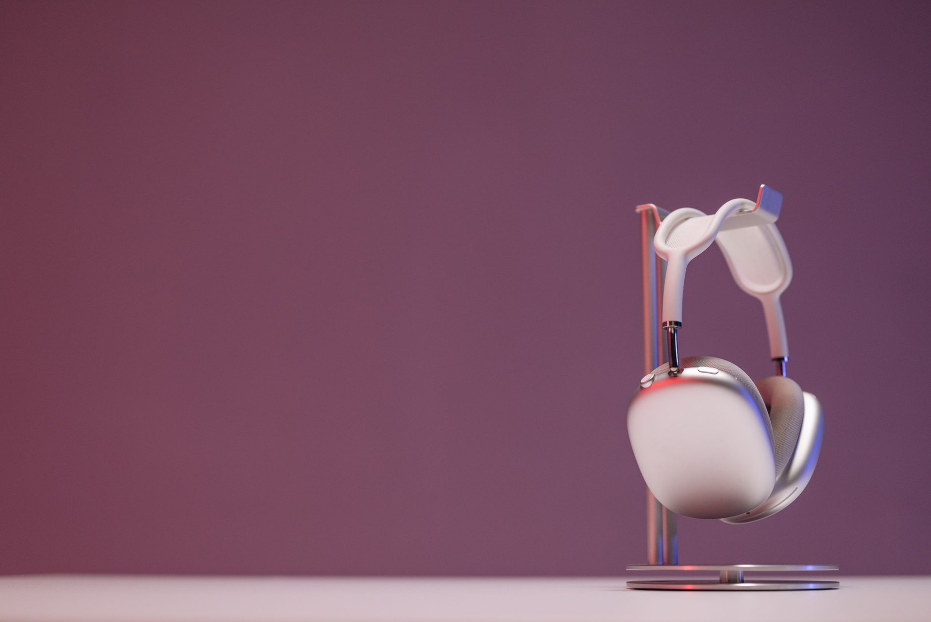 Stylish wireless headphones on a sleek stand against a purple background, perfect for audio tech promotions.
